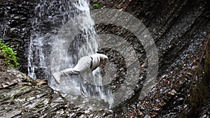 Woman doing yoga waterfall background nature at a mountain lake. Outdoors meditation.