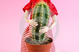 Woman doll hugs a cactus plant on light pink background. Harmful, painful and toxic relationship, partner problems