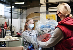 Woman donating clothes community charity donations center, coronavirus concept.