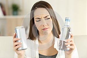 Woman doubting between soda drink and water