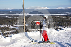 Woman downhill skiing in ski resort area in Lapland Finland