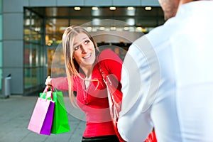 Woman dragging man into shopping mall