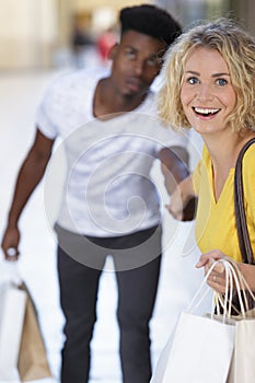 woman dragging man to fashion shopping
