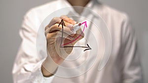 Woman drawing Raise Revenue diagram with red up arrow on transparent screen.