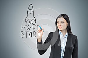 Woman drawing a rocket on glassboard