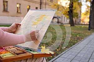 Woman drawing with soft pastels on street, closeup