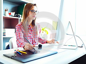 Woman drawing something on graphic tablet at the home office