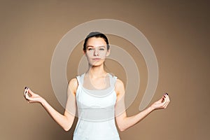 Woman with drawn hair in sports uniform is doing yoga in the studio. A girl in a lotus position and meditates. Home isolation,
