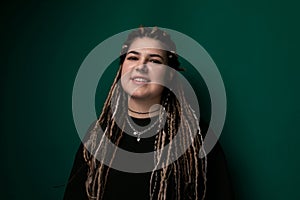 Woman With Dreadlocks in Front of Green Wall