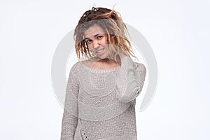 Woman with dreadlocks frowning her face having doubt and suspicion feeling