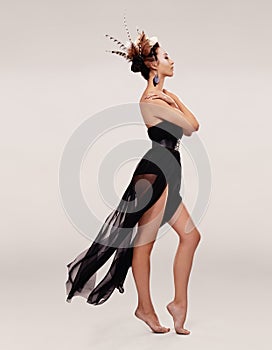 Woman, dress and fashion in studio for feathers in hair, art deco and trendy for glamour, chiffon and clothes. Model or