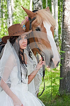 woman in the dress of fiancee next to a horse