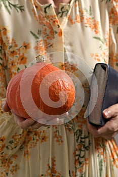 Woman In Dress Hold In Hands  Decorative Pumpkin and Bible