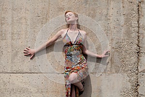 Woman in Dress Leaning Against Wall