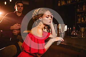 Woman in dress and man behind bar counter, flirt