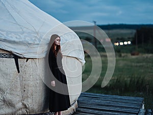 A woman in a dress near the traditional Mongolian dwelling yurt