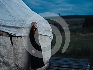 A woman in a dress near the traditional Mongolian dwelling yurt