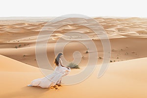 Woman in dress, sand dunes in desert, warm evening light, beautiful pastel tone