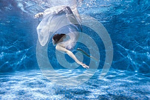 Woman in a dress under the water.