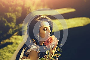 Woman with dress and veil at red rose.