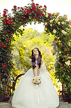 Woman with dress and veil at rose bouquet.