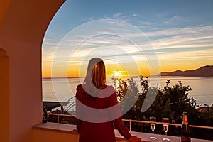 Woman in dress with view from a luxury apartment on the Mediterranean Sea in Praiano, Amalfi Coast, Campania, Italy, Europe.
