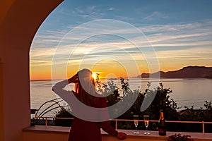 Woman in dress with view from a luxury apartment on the Mediterranean Sea in Praiano, Amalfi Coast, Campania, Italy, Europe.