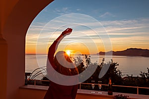 Woman in dress with view from a luxury apartment on the Mediterranean Sea in Praiano, Amalfi Coast, Campania, Italy, Europe.