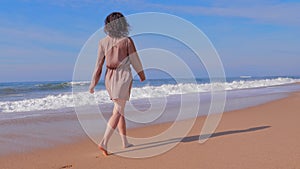 Woman in dress walking on summer beach