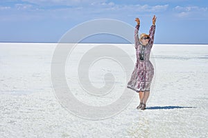 Woman in dress on a white salt lake, portrait of a woman on a white salt lake