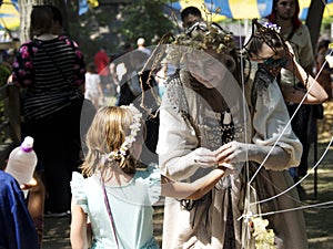 Woman dressed as fairy interacting with a young girl at the Bristol Renaissance Faire