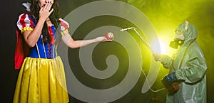 Woman dressed as fairytale character holds Radioactive atomic nuclear ionizing radiation danger warning symbol on apple