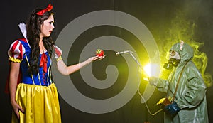 Woman dressed as fairytale character holds Radioactive atomic nuclear ionizing radiation danger warning symbol on apple