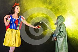 Woman dressed as fairytale character holds Radioactive atomic nuclear ionizing radiation danger warning symbol on apple