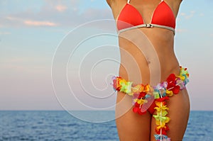 Woman dressed in bathing suit stands on beach