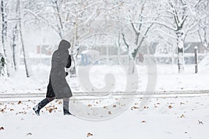 Woman dressed in black coat walking alone