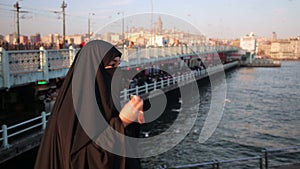 Woman dressed with black headscarf, chador eating, istanbul city