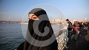 Woman dressed with black headscarf,chador on istanbul street,turkey