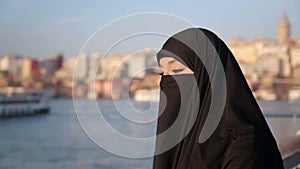 Woman dressed with black headscarf,chador on istanbul street,turkey