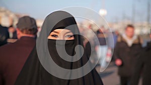 Woman dressed with black headscarf,chador on istanbul street,turkey