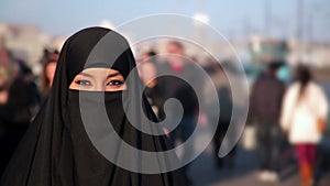 Woman dressed with black headscarf,chador on istanbul street,turkey