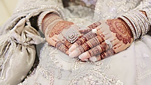 Woman dressed in traditional white Indian clothes, and piaint of hand mehndi. Hindu wedding element. Close up of hands