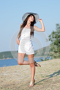 Woman dressed with white coveralls rompers joying the sunny day photo