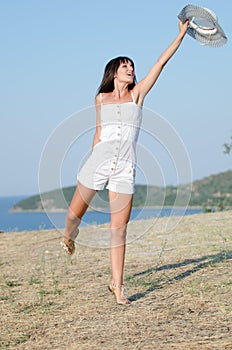 Woman dressed with white coveralls rompers joying the sunny day