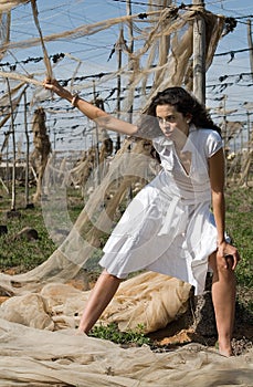 Woman dressed in white in a wasteland of abandoned crops