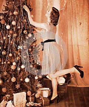 Woman dressing Christmas tree.