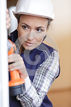 Woman drilling wall in new house