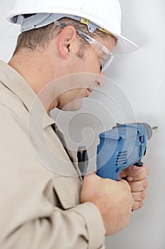 woman drilling wall in new house