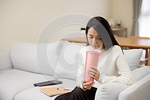 Woman drink bottle of water at home