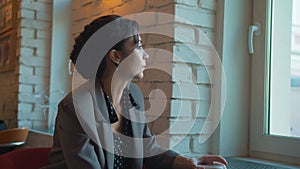 Woman drink coffee, look out the window thoughtfully